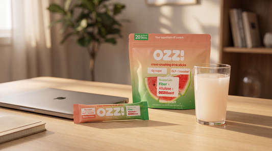 Ozzi watermelon drink stick pouch, a single stick pack and a glass of the prepared Ozzi drink on a home office desk
