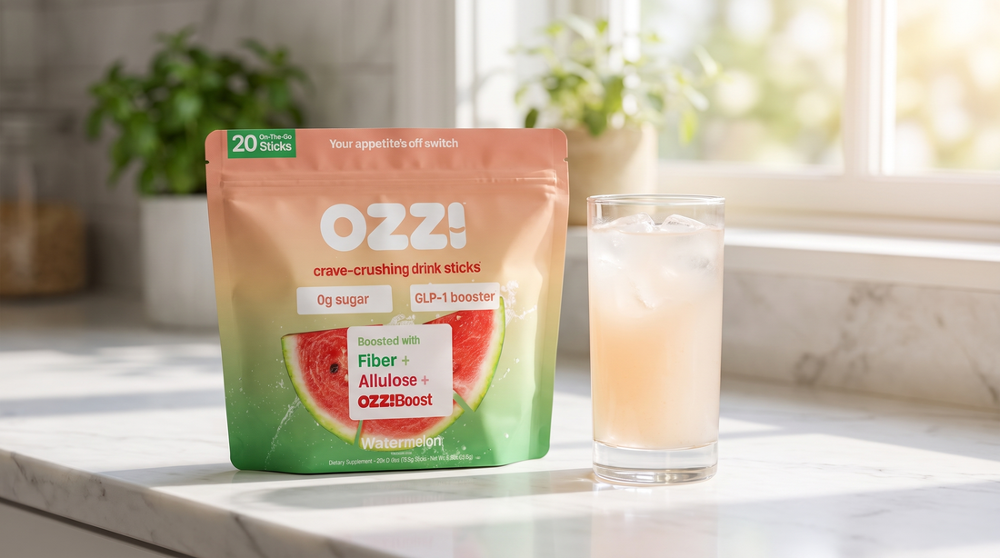 Ozzi watermelon pouch on a kitchen counter beside a glass of the prepared cloudy off-white drink with ice