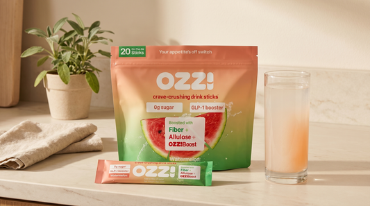 OZZ! watermelon stick pack pouch with a single stick and a glass of the prepared Ozzi drink on a calm kitchen counter
