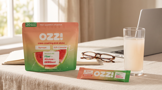 Ozzi Crave Crusher pouch and stick pack beside a glass of the prepared drink on a bright home office desk