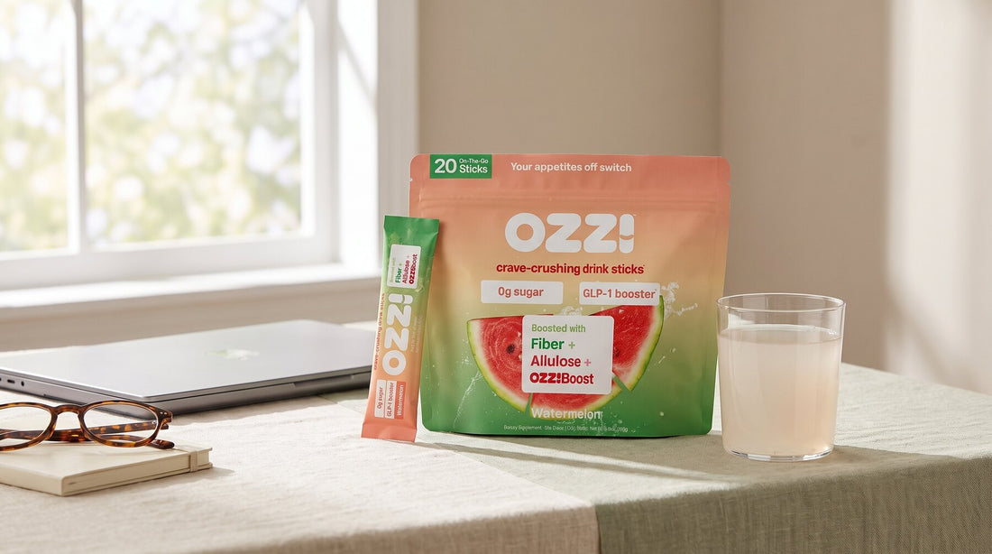 Ozzi watermelon drink stick pouch and stick pack on a sunlit desk beside a glass of the prepared drink